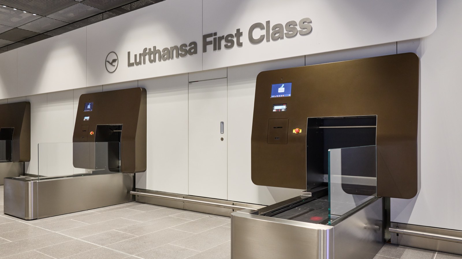 A premium check-in area with automated bag-drop belts and a suitcase on the scale