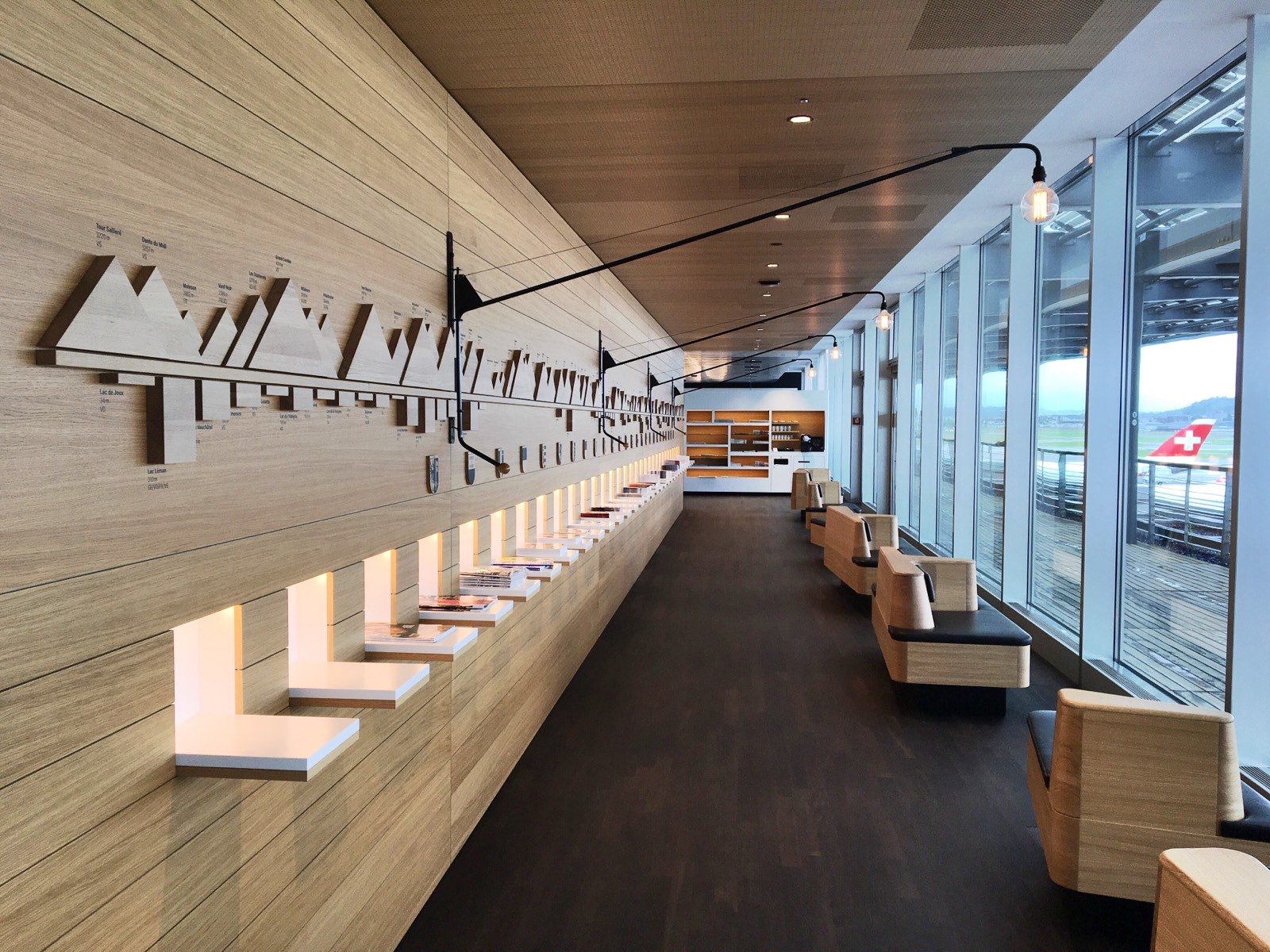 A SWISS lounge at Zurich Airport, with seating, a bar counter and windows onto the pier